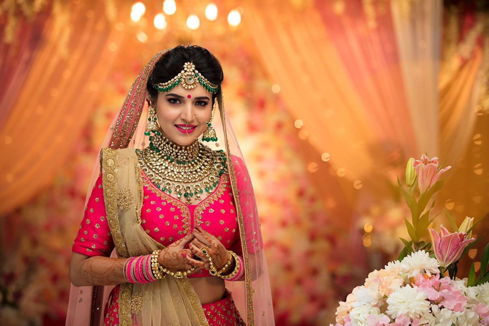 Bride in a pink lehenga and gold jewellery