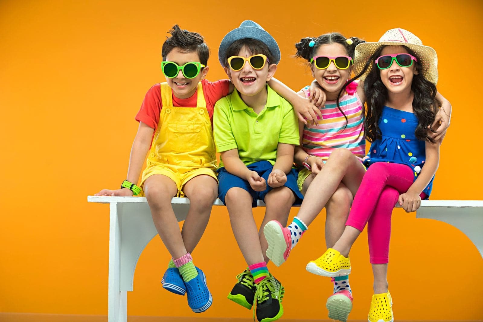 Group of smiling kids in colourful sunglasses