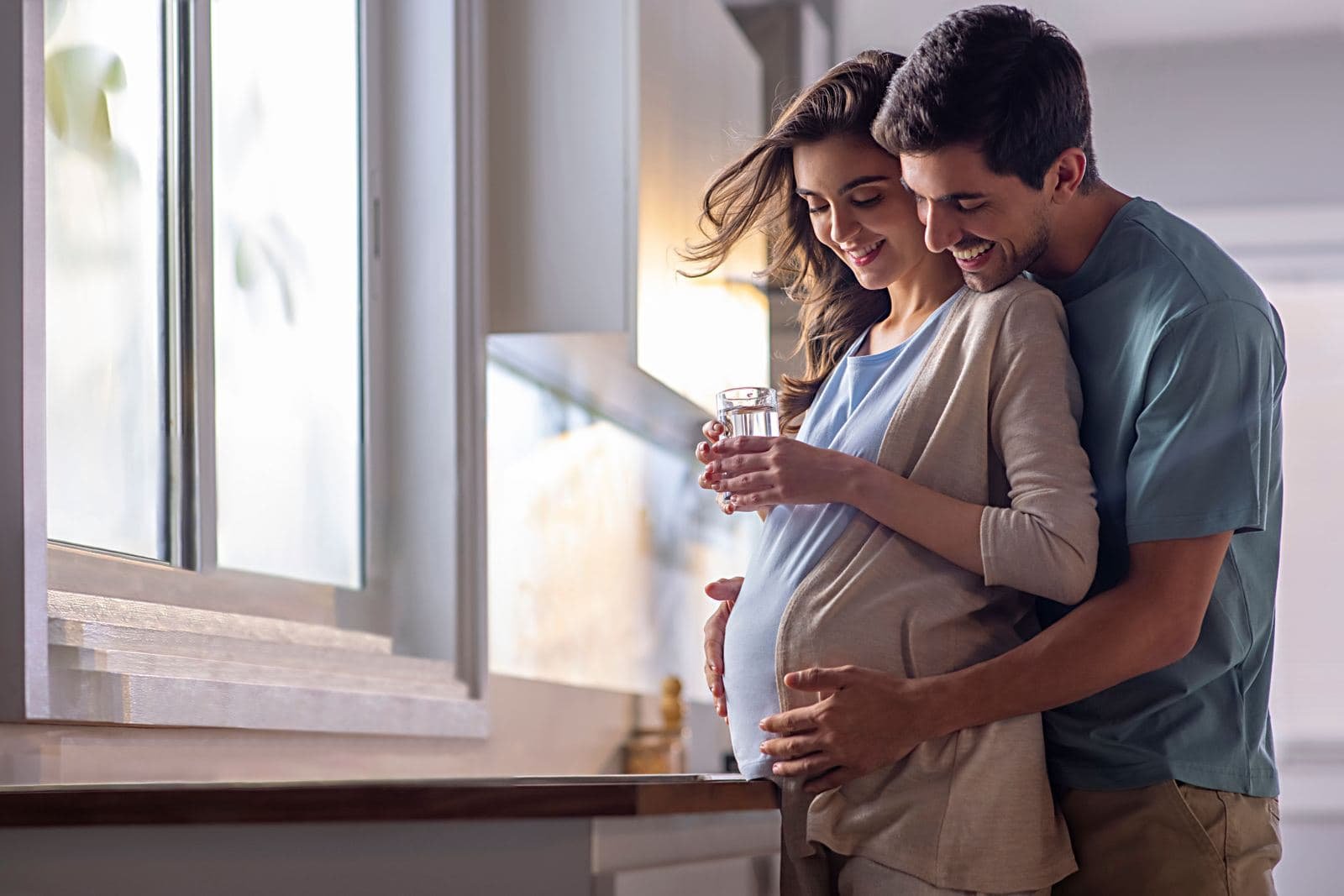 Expecting couple smiling together at home