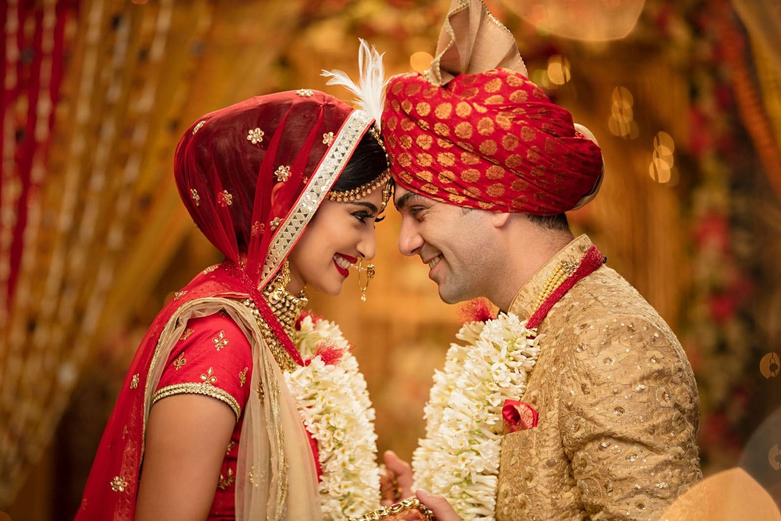 Bride and groom in red and gold wedding attire